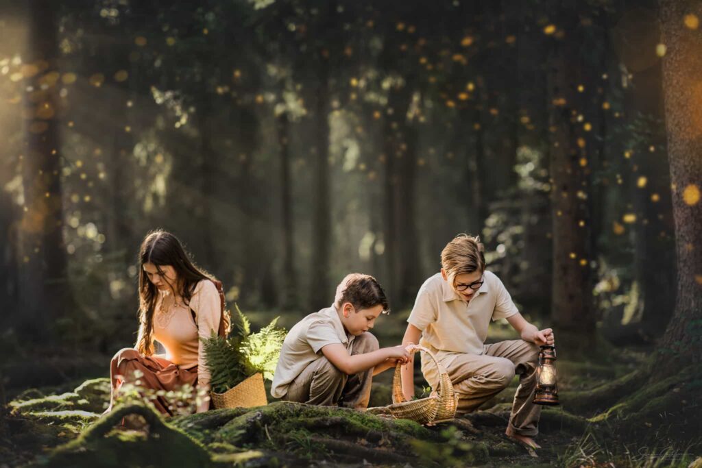 Barnfotograf i skogen – tre barn med korgar och lyktor under sagolik barnfotografering